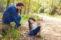 Mother daughter in a park picking clover plants