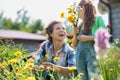 Mother and daughter picking pretty colourful flowes in their organic garden