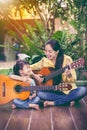 Mother with daughter play guitar. Family spending time together Royalty Free Stock Photo