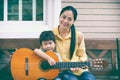 Mother with daughter play guitar. Family spending time together Royalty Free Stock Photo