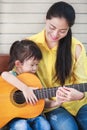 Mother with daughter play guitar. Family spending time together Royalty Free Stock Photo