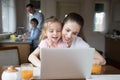 Mother and daughter playing computer while father and son cooking Royalty Free Stock Photo