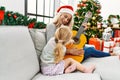 Mother and daughter playing guitar and singing sitting by christmas tree at home Royalty Free Stock Photo