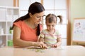 Mother and daughter playing at home. They assembling Jigsaw Puzzle. Royalty Free Stock Photo