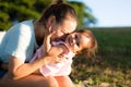 Mother and daughter playing and laughing together in park