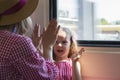 Mother and daughter playing patty-cake sitting near window of moving speed train Royalty Free Stock Photo