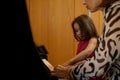 Mother and daughter playing piano together at home. Music. People. Hobbies and leisure Royalty Free Stock Photo