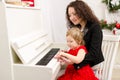 Mother and daughter playing on white piano Royalty Free Stock Photo