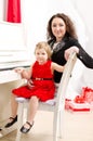 Mother and daughter playing on white piano Royalty Free Stock Photo