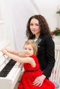 Mother and daughter playing on white piano Royalty Free Stock Photo