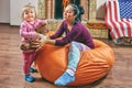 Mother and daughter plays on bean bag chair Royalty Free Stock Photo