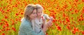 Mother and daughter on the poppies field background. Spring family banner. Beautiful child girl with young mother are Royalty Free Stock Photo