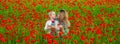 Mother and daughter on the poppies field background. Spring family banner. Happy family resting on a beautiful poppy Royalty Free Stock Photo