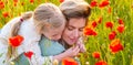 Mother and daughter on the poppies field background. Spring family banner. Portrait of mother and daughter walking