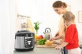 Mother and daughter preparing food near modern multi cooker Royalty Free Stock Photo