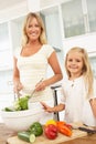 Mother & Daughter Preparing Salad In Kitchen