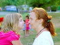 Mother and daughter profile playing in park