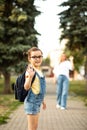 Mother and daughter pupil walking to school. Mom leads little school child first day at school