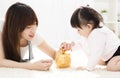 Mother and daughter putting coins into piggy bank Royalty Free Stock Photo