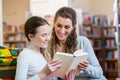 Mother and daughter reading a book in community center library Royalty Free Stock Photo