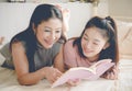Mother and daughter reading a book and happy together at home,family concept. Royalty Free Stock Photo