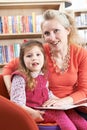 Mother And Daughter Reading Book In Library Royalty Free Stock Photo