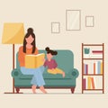 Mother with daughter, reading book together, sitting on sofa. Mom with child on chair in room. Parent with kid at home. Royalty Free Stock Photo