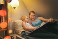 Mother and daughter reading fairy tail book together in the evening before sleep Royalty Free Stock Photo