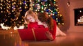 Mother and daughter reading at fire place on Christmas eve Royalty Free Stock Photo