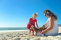 Mother and daughter in red dress and dog on the beach Royalty Free Stock Photo