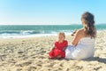 Mother and daughter in red dress and dog on the beach Royalty Free Stock Photo