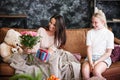 Mother and daughter relationship concept. A teenage girl congratulates happy woman on her birthday and gives her