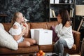 Mother and daughter relationship concept. A woman congratulates happy teenage girl on her birthday and gives her a gift Royalty Free Stock Photo