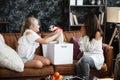 Mother and daughter relationship concept. A woman congratulates happy teenage girl on her birthday and gives her a gift Royalty Free Stock Photo