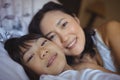 Mother and daughter relaxing on bed in bed room Royalty Free Stock Photo