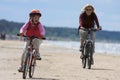 Mother and daughter riding along the beach Royalty Free Stock Photo