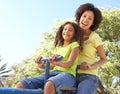 Mother And Daughter Riding On Seesaw In Park