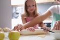 Mother and daughter roll out dough in kitchen at home closeup Royalty Free Stock Photo