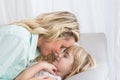 Mother and daughter rubbing noses on sofa Royalty Free Stock Photo