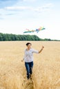 Mother and daughter run in a wheat field with a kite in the summer. Well-planned and active weekend. Happy childhood. Royalty Free Stock Photo