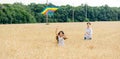 Mother and daughter run in a wheat field with a kite in the summer. Well-planned and active weekend. Happy childhood. Royalty Free Stock Photo