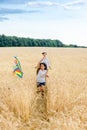 Mother and daughter run in a wheat field with a kite in the summer. Well-planned and active weekend. Happy childhood. Royalty Free Stock Photo