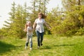 Mother and daughter running across the meadow