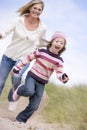 Mother and daughter running on beach smiling Royalty Free Stock Photo