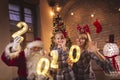 Mother, daughter and Santa holding illuminative numbers 2020 Royalty Free Stock Photo