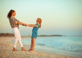 Mother and daughter on seacoast in evening having fun time Royalty Free Stock Photo