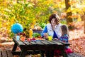 Mother and daughter set table for picnic in autumn Royalty Free Stock Photo