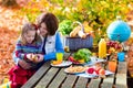 Mother and daughter set table for picnic in autumn Royalty Free Stock Photo