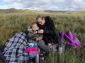 A mother and daughter sharing a cup of tea, sat among the long grass on top of a hill in Wales.