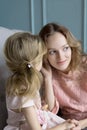 Mother and daughter sharing secrets at home in the living room